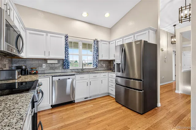 a kitchen with stainless steel appliances granite countertop a refrigerator sink and microwave