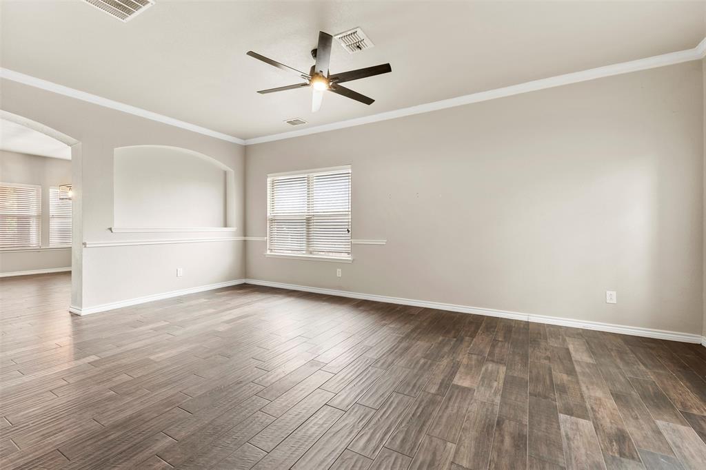 6522 Portside Ridge Lane Dallas, TX 75249 - Photo 5 of 37 Spacious room featuring wood-finish flooring, a ceiling fan with integrated lighting, and multiple windows with blinds