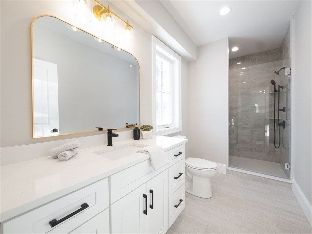 22 Bradford Road Natick, MA 01760 - Photo 19 of 37 a bathroom with a double vanity sink toilet mirror and shower
