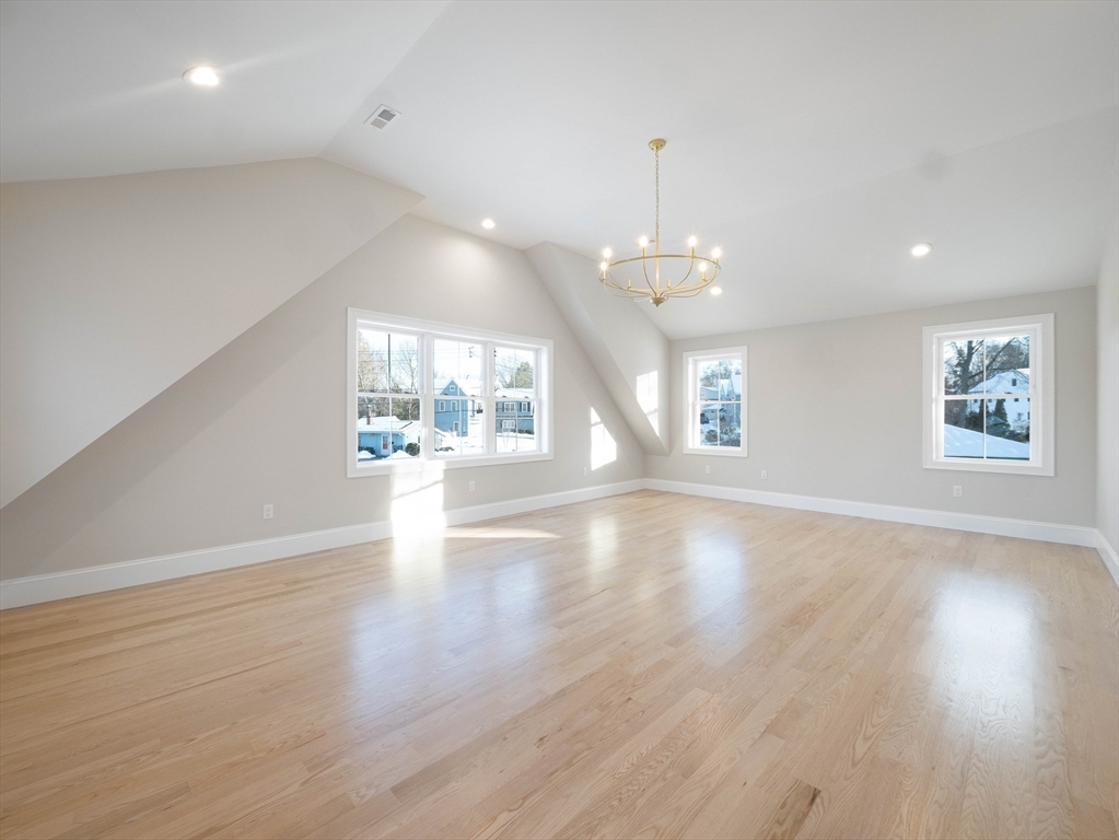 22 Bradford Road Natick, MA 01760 - Photo 21 of 37 an empty room with wooden floor chandelier and windows