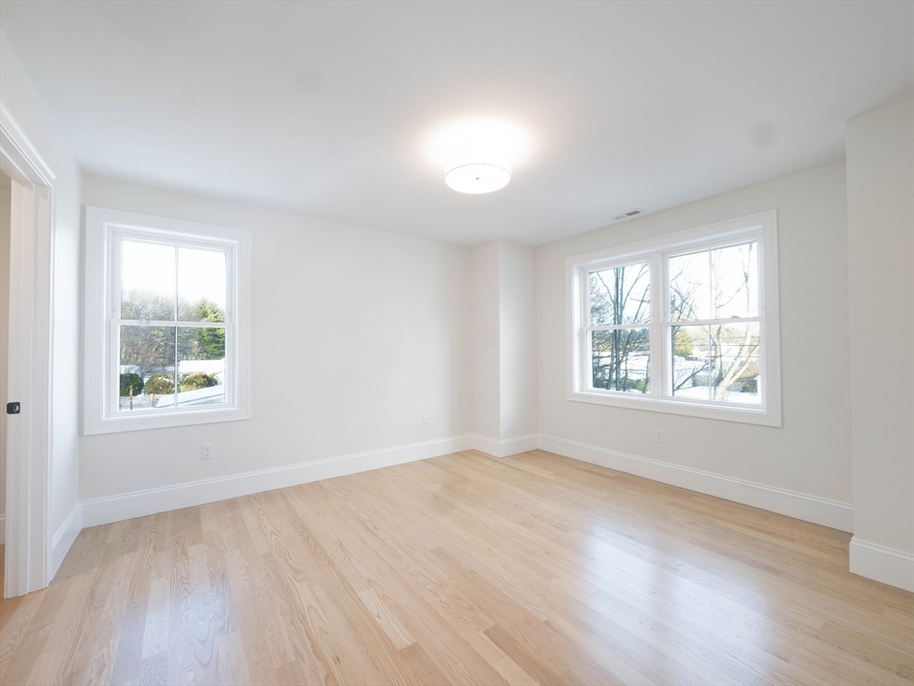 22 Bradford Road Natick, MA 01760 - Photo 28 of 37 a view of an empty room with wooden floor and a window