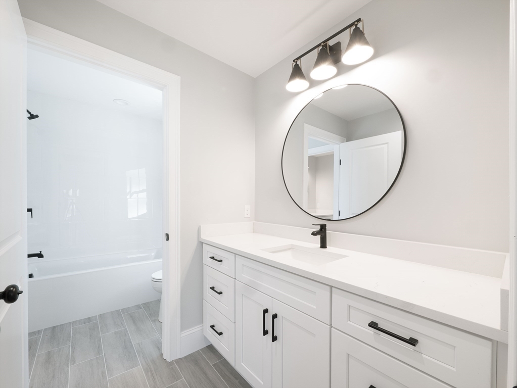 22 Bradford Road Natick, MA 01760 - Photo 29 of 37 a bathroom with a sink a mirror and a bathtub