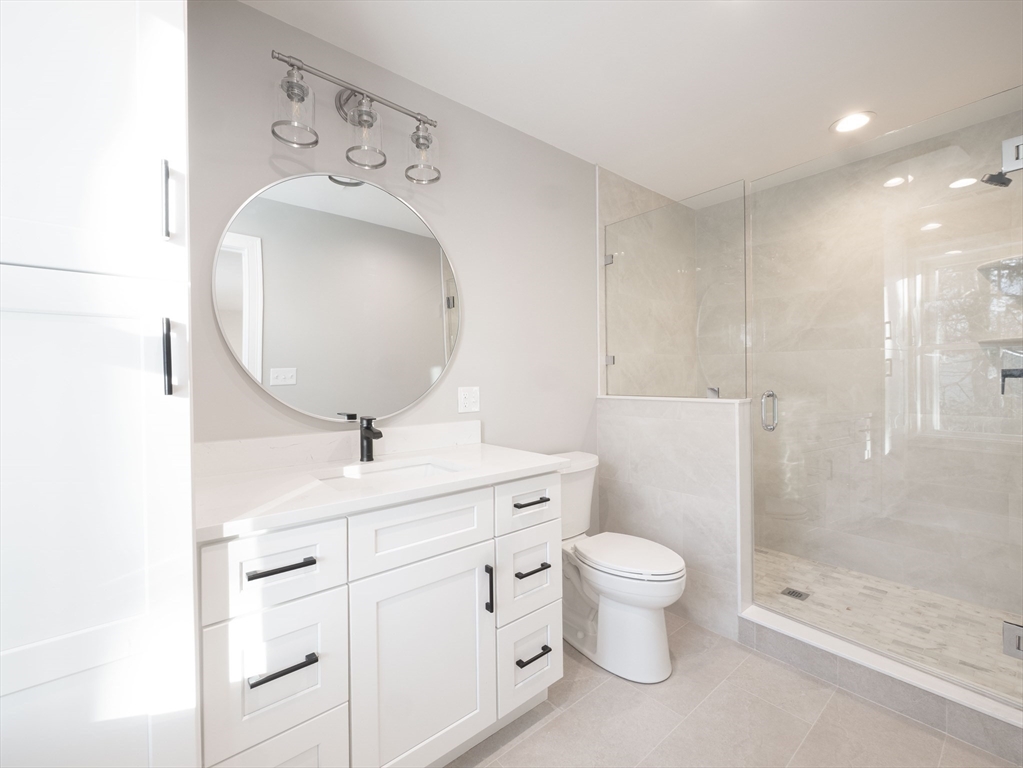 22 Bradford Road Natick, MA 01760 - Photo 36 of 37 a bathroom with a sink a toilet and a mirror