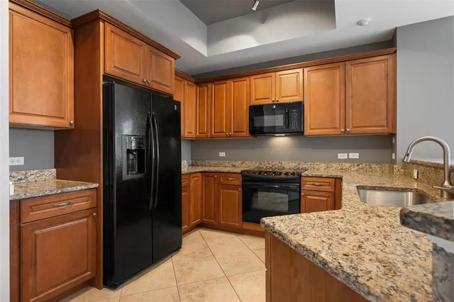 a kitchen with stainless steel appliances granite countertop refrigerator sink and stove