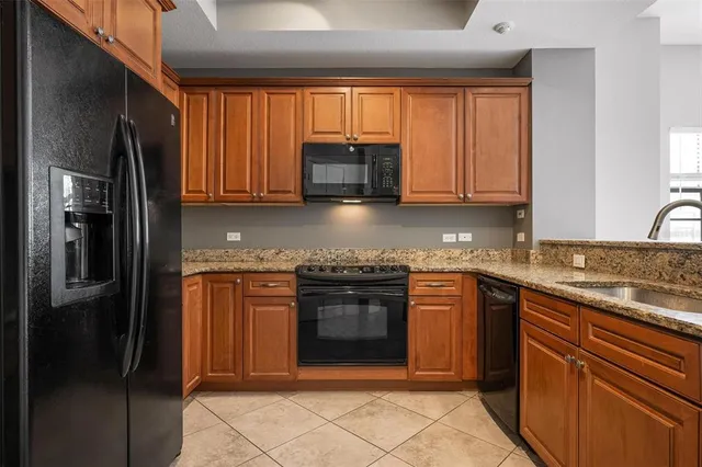 a kitchen with stainless steel appliances granite countertop a stove a refrigerator and a sink