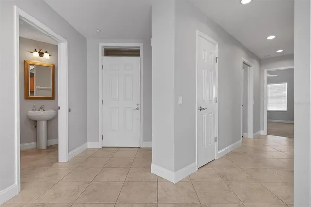 a view of a hallway with wooden floor and a bathroom
