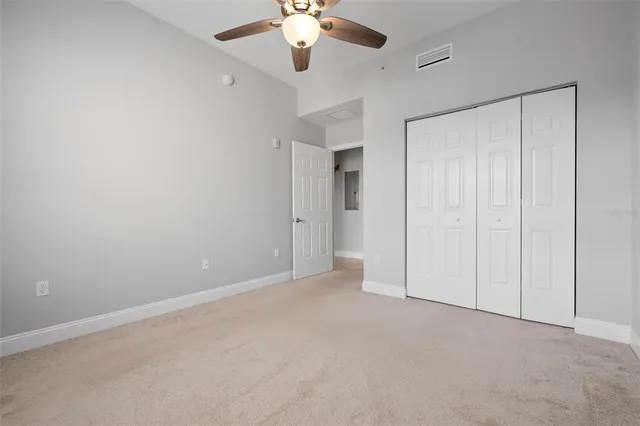 an empty room with windows and fan