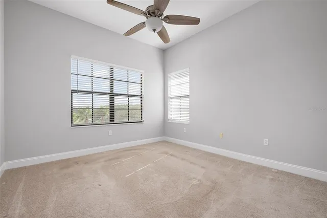 a view of an empty room and a ceiling fan