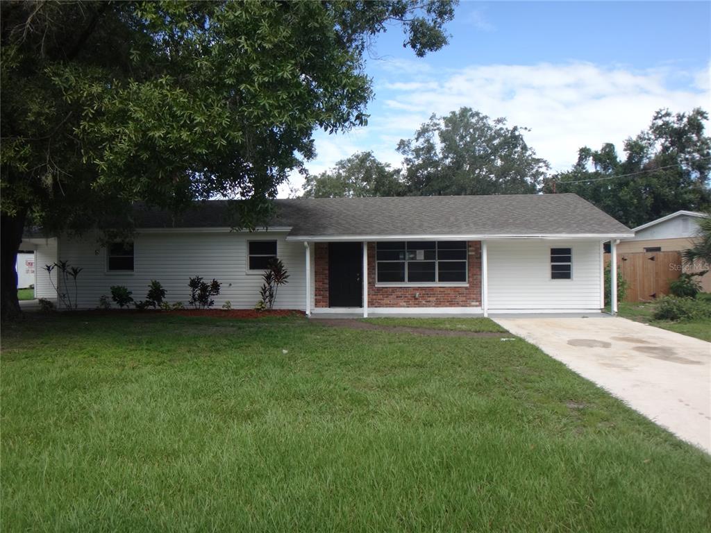 a front view of house with a garden and trees