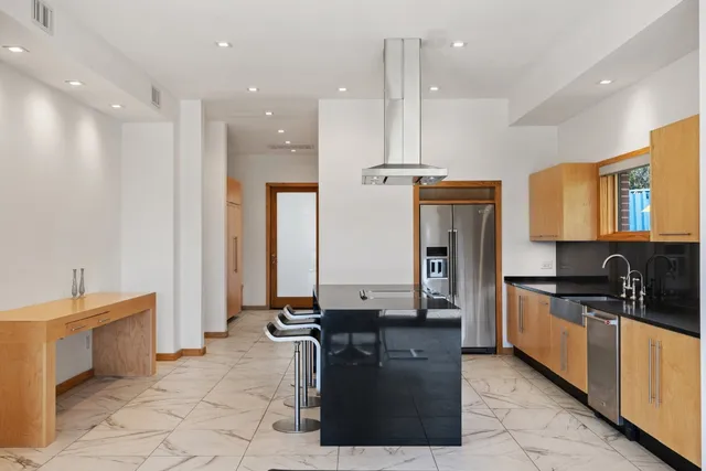 a kitchen with stainless steel appliances granite countertop a sink a stove and a refrigerator