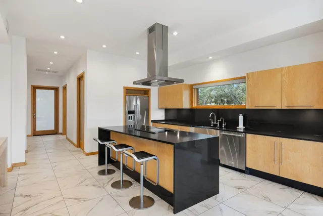 a kitchen with stainless steel appliances a stove a sink and a refrigerator