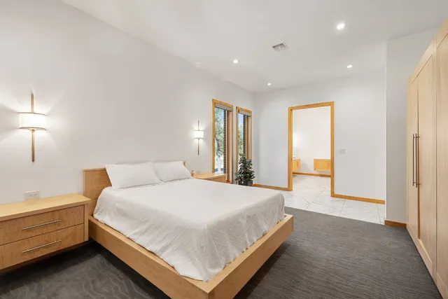 a spacious bedroom with a bed and a lamp