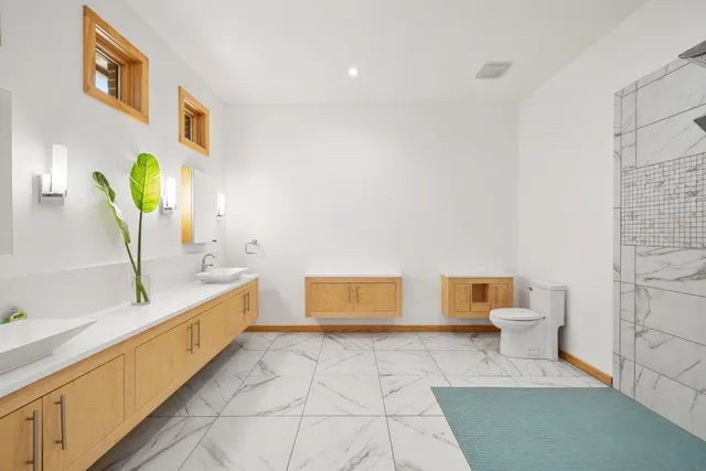 a bathroom with a sink a toilet and a mirror