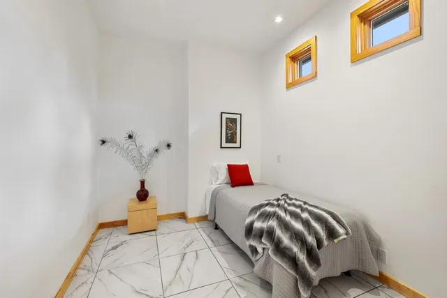 a bedroom with a bed and a painting on the wall