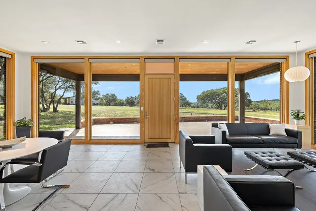 a living room with furniture and large windows