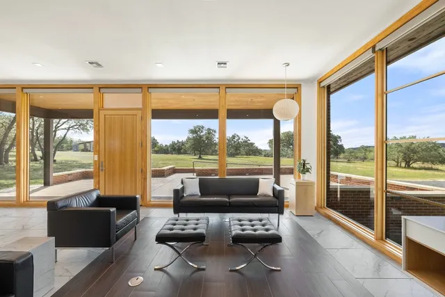a living room with furniture and a floor to ceiling window