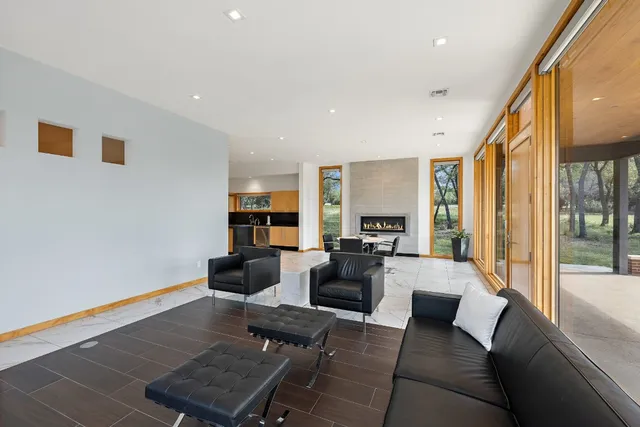 a living room with furniture fireplace and large window