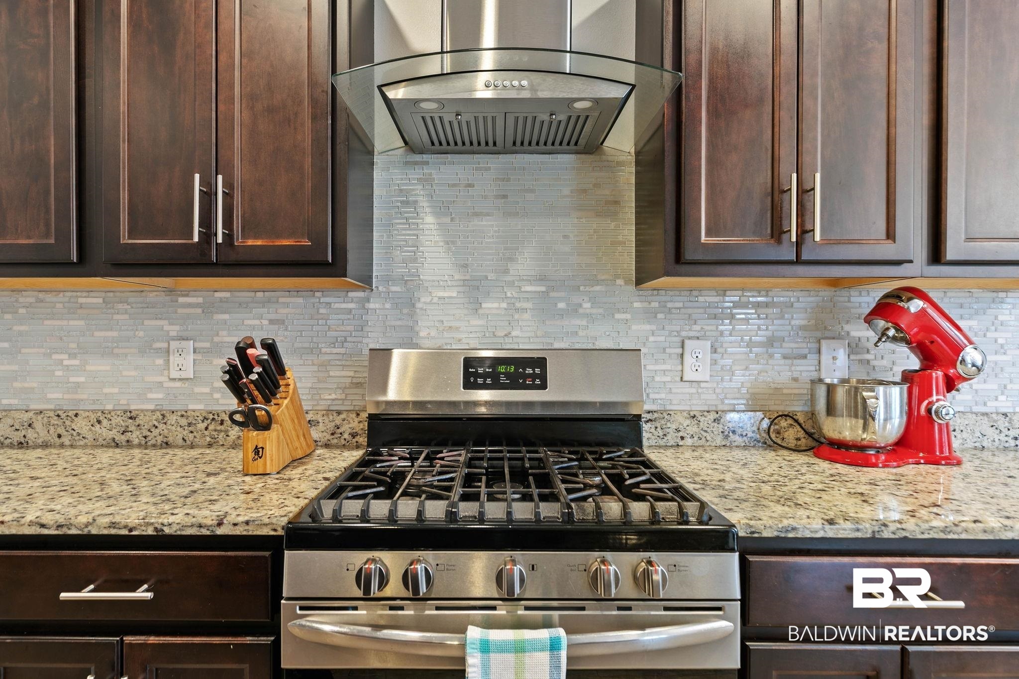 31350 Hoot Owl Road Daphne, AL 36527 - Photo 19 of 94 Kitchen featuring stainless steel range with gas cooktop, dark wood finish cabinets, and light stone countertops