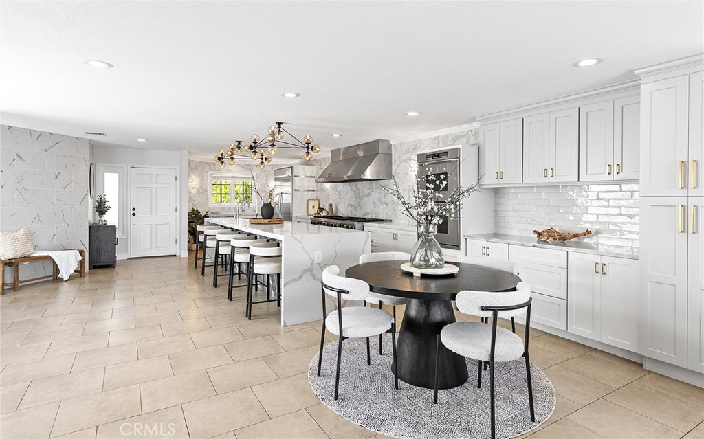 23966 Wanigan Way Laguna Niguel, CA 92677 - Photo 14 of 57 a kitchen with stainless steel appliances kitchen island granite countertop a table and chairs in it