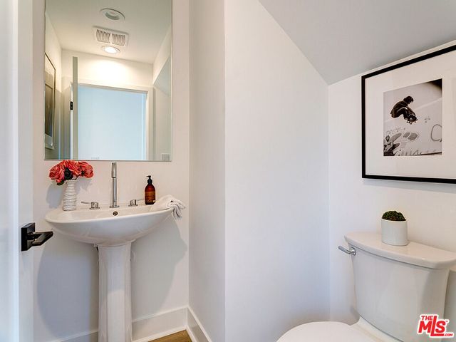 a bathroom with a sink mirror and toilet