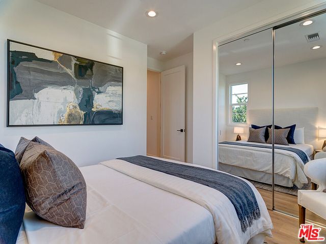 a bedroom with a bed and painting on the wall