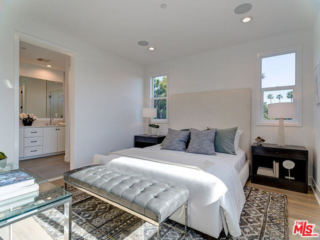 a bedroom with a bed and a lamp on dresser