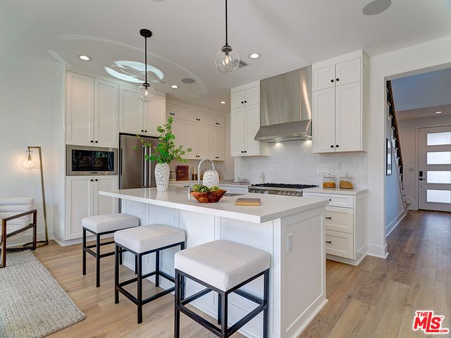 a kitchen with white cabinets and stainless steel appliances