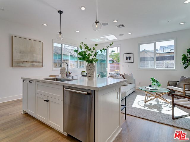 a kitchen with stainless steel appliances granite countertop sink table and chairs