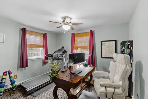 a living room with furniture a flat screen tv and a window