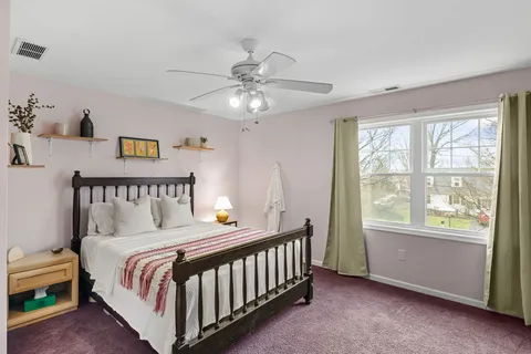 a bed sitting in a bedroom next to a window