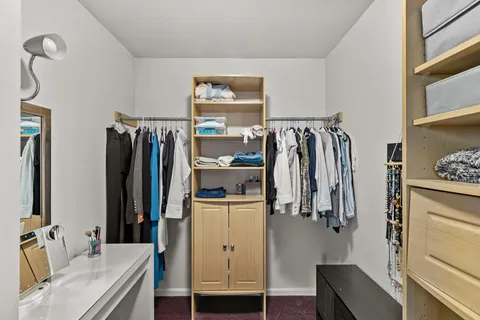 a view of walk in closet with clothes and shoes