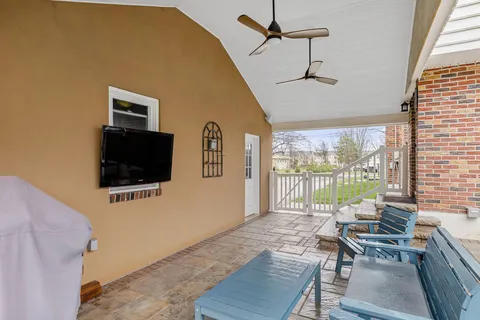 a living room with furniture a flat screen tv and a large window