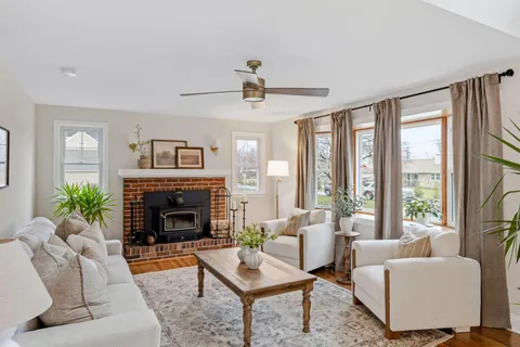 a living room with furniture fireplace and a large window