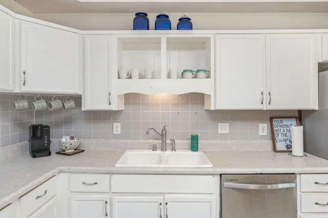 a view of a kitchen with granite countertop cabinets and chairs