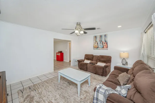 a living room with furniture a flat screen tv and a table