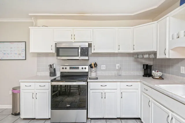 a kitchen with white cabinets and white appliances