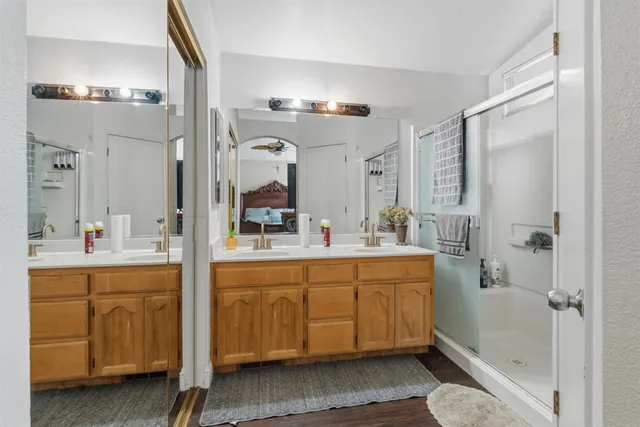 a bathroom with a double vanity sink mirror and shower