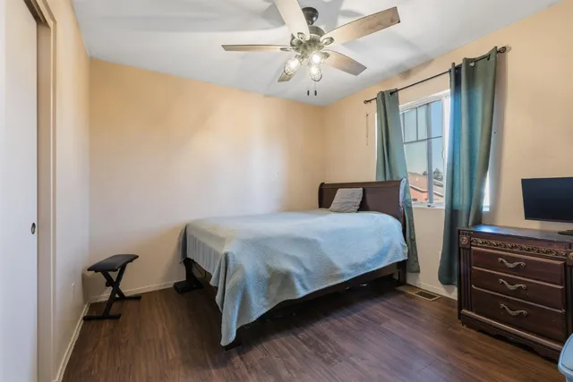 a bedroom with a bed dresser and a flat tv screen