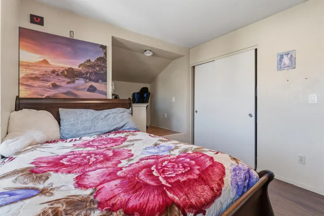 a bedroom with a bed and a painting on the wall