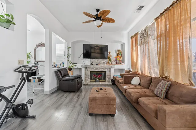 a living room with furniture a fireplace a flat screen tv and a window