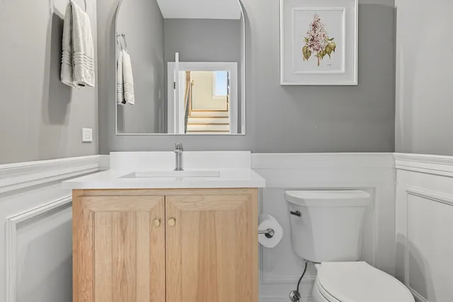 a bathroom with a granite countertop toilet sink and mirror