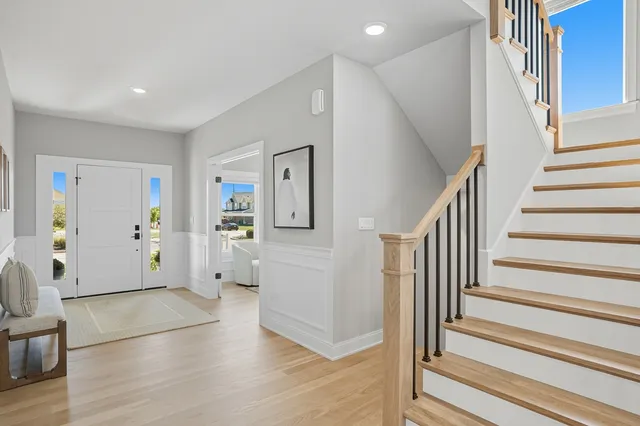 a view of a livingroom with wooden floor and stairs