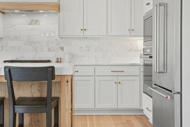 a kitchen with white cabinets and a refrigerator