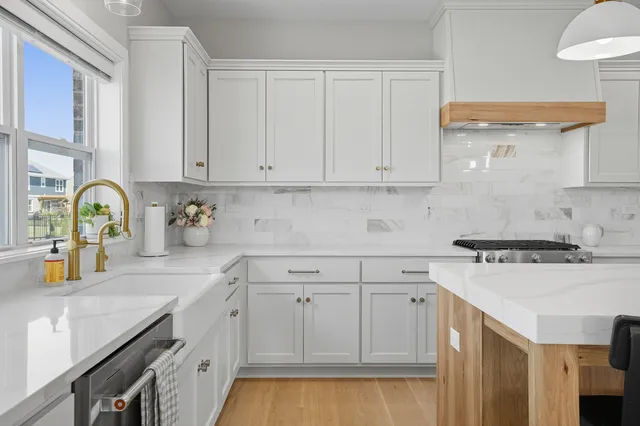 a kitchen with white cabinets and sink