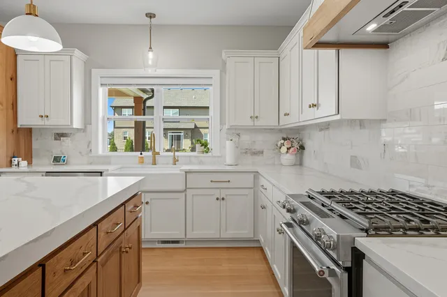 a kitchen with granite countertop a sink stove and cabinets