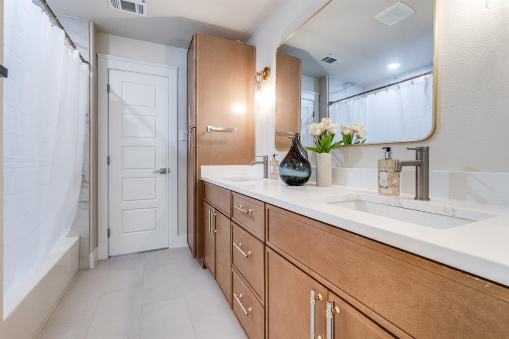7115 Meadow Road Dallas, TX 75230 - Photo 10 of 22 Bathroom featuring a double vanity with light wood cabinetry, white countertops, and a large mirror