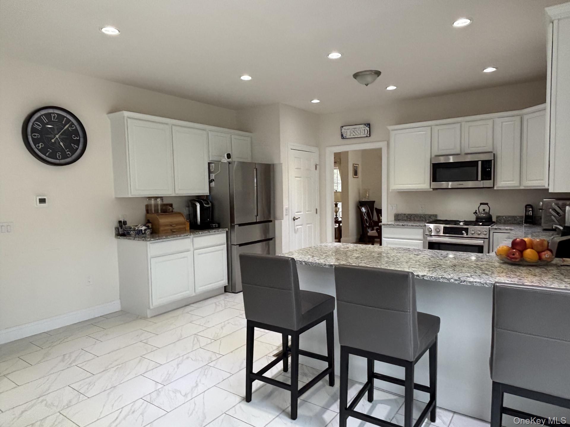 657 Sackett Lake Road Monticello, NY 12701 - Photo 5 of 36 a kitchen with stainless steel appliances a refrigerator a stove a sink a dining table and chairs