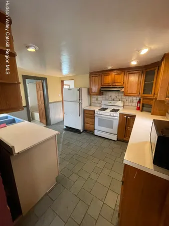 a kitchen with a refrigerator and a stove top oven