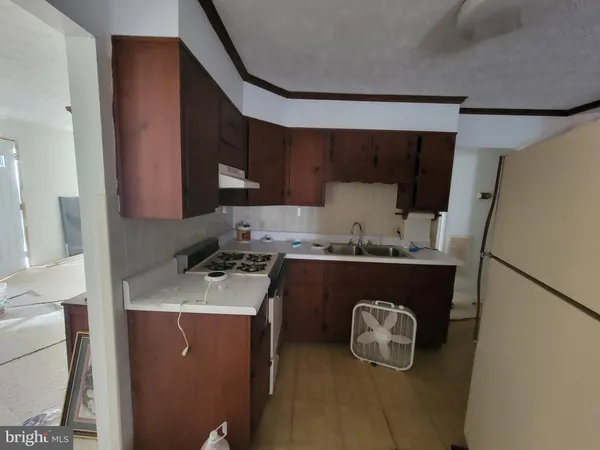 a kitchen with a sink a stove and a refrigerator