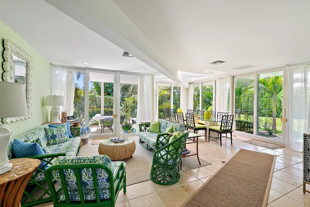 a living room with furniture and floor to ceiling windows